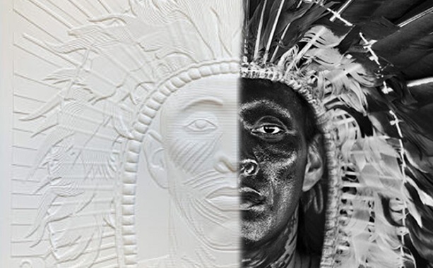 Photo d'un homme portant une coiffe en plumes d'aigle et des peintures sur le visage. D'un côté, l'image est en relief tactil de l'autre il s'agit d'une photo.
